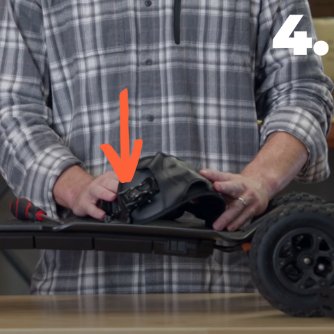 Photo d'un homme en train d'ajuster et de régler les straps sur mountainboard